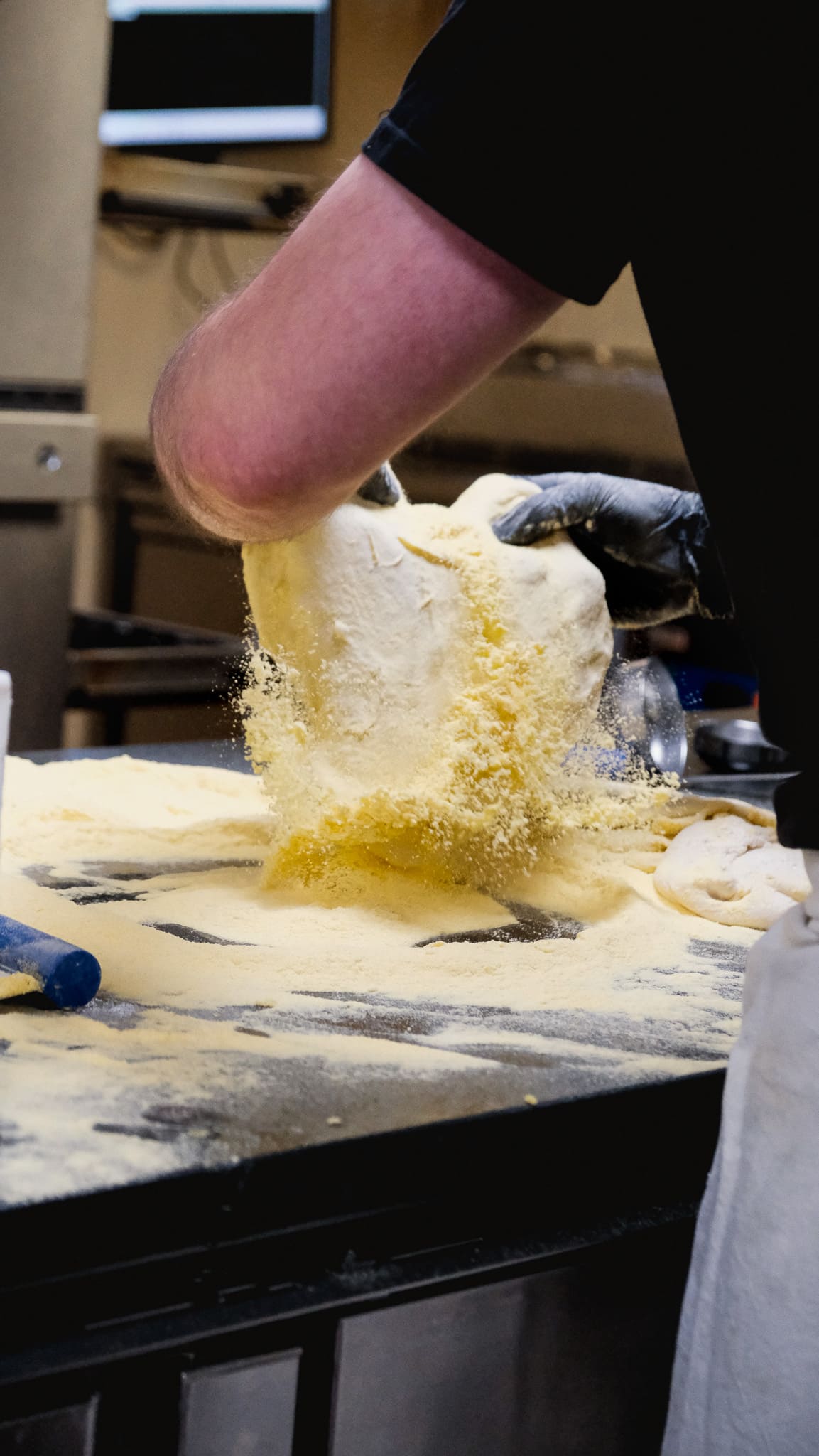 Façonnage de la pâte à pizza dans la semoule, en cuisine chez Fabioli
