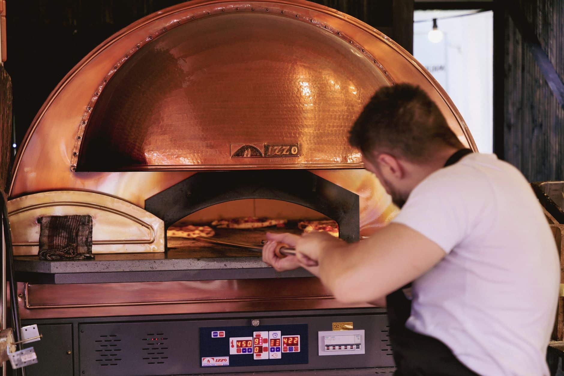Pizzaiolo façonnant une pâte à pizza dans un restaurant italien